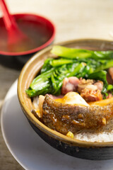 angle view clay pot rice with cured pork and fish and vegetable