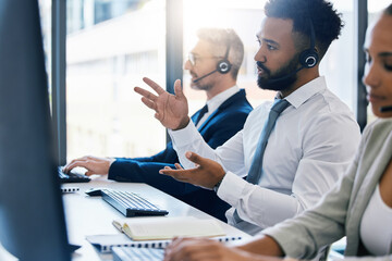 Call center, customer care and support with a man consultant in a headset working on a computer in...