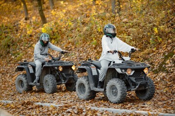 Man and woman driving quad bike in autumn forest © prostooleh