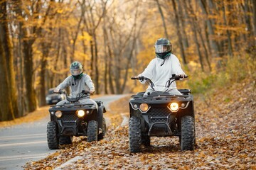 Man and woman driving quad bike in autumn forest © prostooleh