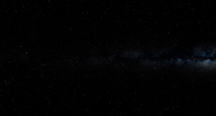 Fototapeta premium A black and white night sky filled with stars, with the Milky Way stretching across the horizon. The stars twinkle in the darkness, creating a beautiful and serene atmosphere.