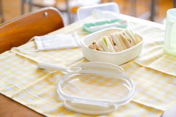 学校の教室　学習机の上のお弁当　