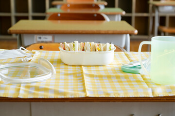 学校の教室　学習机の上のお弁当　