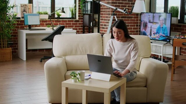 Beautiful freelancer doing remote work on modern laptop while developing business ideas at home. Hurried young adult woman working remotely on startup project because of early deadline.