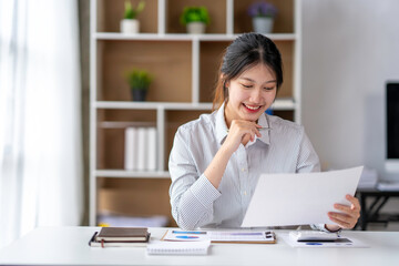 Asian business woman taking notes on online meetings on the Internet through a laptop in an open office business idea Data Analysis, Roadmap, Marketing, Accounting, Auditing