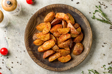 The potatoes wedges on the Board on stone table top view
