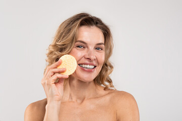 Beauty Care. Attractive Middle Aged Woman Holding Cosmetic Sponge, Smiling At Camera