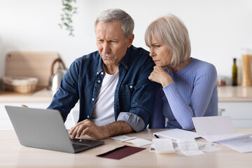 Confused senior husband and wife paying bills on Internet