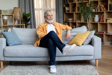 Obraz premium Relaxed elderly man chilling on couch at home
