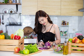 Obraz na płótnie Canvas Beautiful Asian Woman smiling preparing vegetable salad in the kitchen Healthy FoodsVegan SaladsVegetarian SaladFood IdeasDiet IdeasHealthy LifestyleCooking At Home