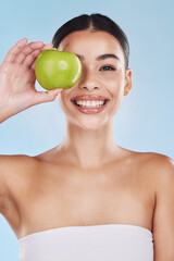 Portrait, health and beauty with woman with an apple for vitamins, minerals or nutrients. Healthy diet, lifestyle and skincare nutrition of girl from Brazil with fruit on her eye and a smile.