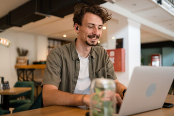 One young adult caucasian man work remote from cafe on laptop computer