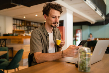 One modern caucasian man using mobile phone while stand at cafe