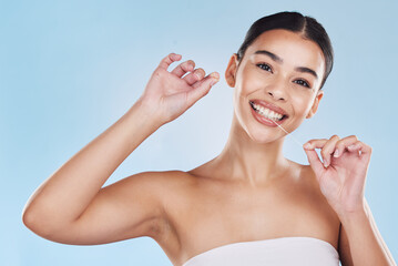 Oral, dental and flossing woman cleaning teeth in a studio blue background mockup. Young model with...