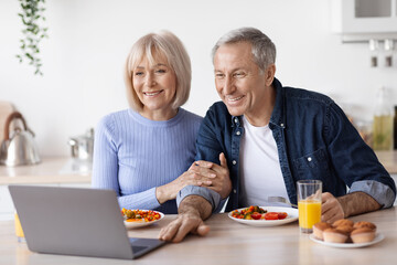 Loving senior couple having video call while having breakfast
