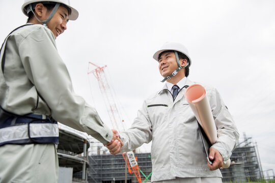 日本人の仕事風景、握手する現場監督　新人教育　イメージ　　施工管理　