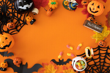 Halloween decorations concept. Top view photo of spooky eyeballs candies on green hand, spiders and pumpkin isolated orange background with empty space.