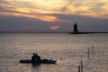 Silhouette of a couple enjoying sunset from a kayak at Cape Henlopen State Park, Lewes, Delaware, U.S © Khairil