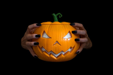 Pumpkin or jack-o-lantern on woman hands close up - holidays, halloween, decoration and Carved halloween spooky pumpkin, Black background.