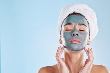 Facial, skincare and woman with face mask cream for beauty, health and wellness in studio with blue background. Cosmetics, product and young girl at luxury spa for acne treatment in a model portrait