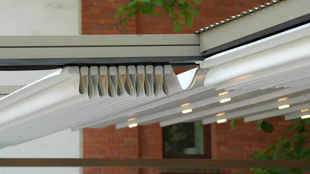 4k video, the move of a retractable awning of roof for protect from sun in garden at home or in terrace at a restaurant. 