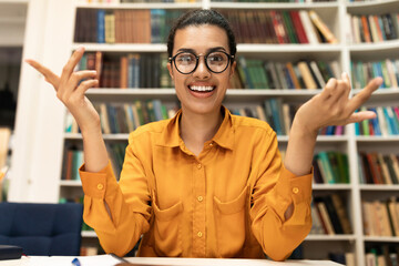 Online tutoring concept. Cheerful young woman in glasses having video conference with students