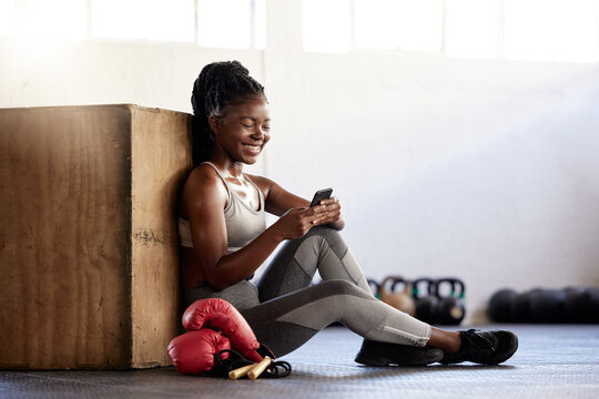 Black Woman Boxer With Phone In Gym Relax, Wellness And Exercise After Sport, Fitness And Training With Smile. Communication, Health And Happy Sports Girl On Technology, Mobile And Smartphone.