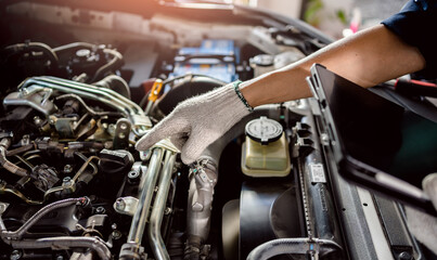Fototapeta premium Automotive mechanic repairman using tablet and checking engine oil level engine in the engine room, check the mileage of the car, oil change, auto maintenance service concept