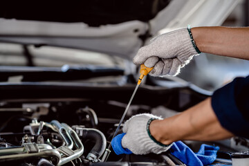 Close up of Automotive mechanic repairman pulling dipstick to checking engine oil level engine in...