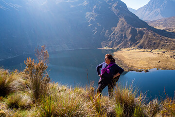 portrait of a latin woman, on top of a hill with a lake in the background