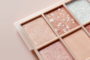 Fototapeta premium Eyeshadow colorful shades palette in beige tones close-up. Beauty abstract background