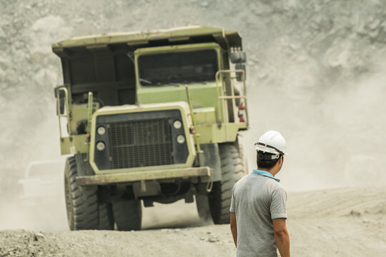 Miner Worker Engineer Standing With Big Mining Dumping Truck In Background