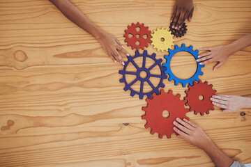 Success, collaboration and teamwork, people with gears on a wooden table. Diversity, hands and a...