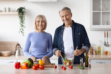 Photo of senior man and woman cooking together at home