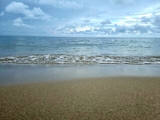 White bubbles of wave crash the sandy beach in the evening no light , for background
