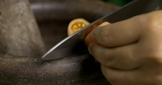 Close-up front view, chef cooking making mix ingredients chili garlic tomato for spicy green papaya salad or Som Tum, Thai traditional street food.