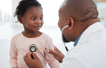 Healthcare, pediatrician and child heart doctor with a patient at hospital, exam on chest with a stethoscope. Black girl smile at pediatric surgeon, talking to a friendly, caring physician she trust