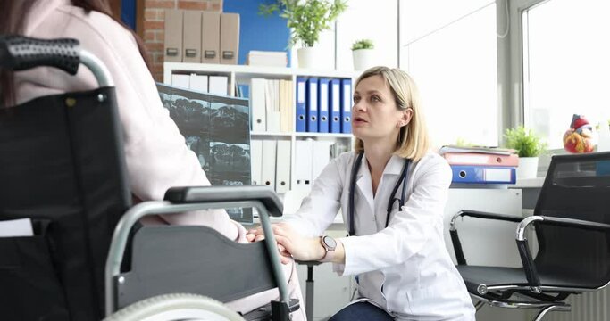 Rehabilitation doctor communicates with woman in wheelchair in surgery