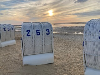 Strandkörbe am Strand der Nordsee in Cuxhaven Duhnen bei Sonnenuntergang