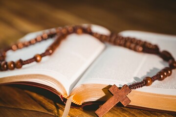 Naklejka premium Rosary beads kept on open bible
