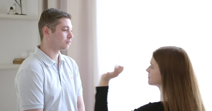 Angry woman slapping husband's face and pushing him away