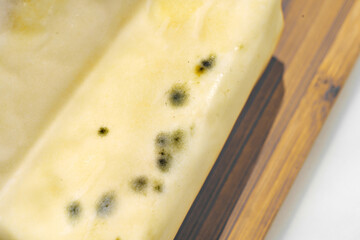 a pack of spoiled butter with mold. the storage of dairy products.