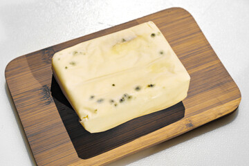 a pack of spoiled butter with mold on a wooden board