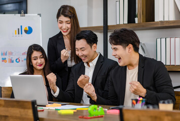 Group of millennial Asian young professional successful male businessmen and female businesswomen in formal suit sitting standing smiling screaming shouting holding fists up celebrating together