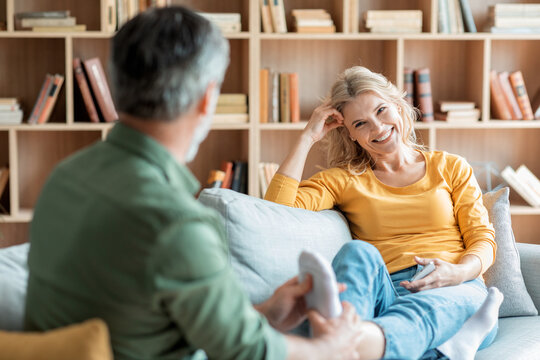 Caring Man Massaging Feet Of His Wife While They Relaxing On Couch