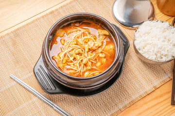 Korean traditional food, Soybean sprout soup in hot iron pot on wooden table, Kongnamul guk.
