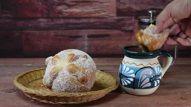 pov view of person eating day of the dead bread in mexican coffee cup