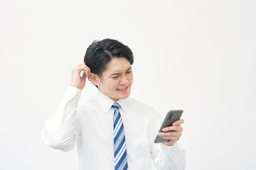 白背景でスマホを持って困るビジネスマン