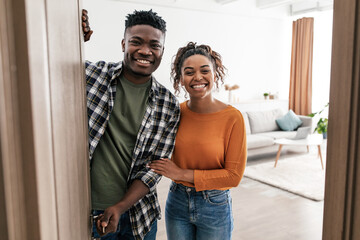 Cheerful Black Couple Opening Entry Door Posing At Home