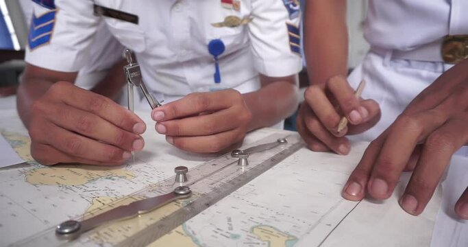 Student study Navigation ship chart for building a sailing route. Maps of the ship for plotting. Plotter, divider, ruler and pen. Nautical education. Close-Up